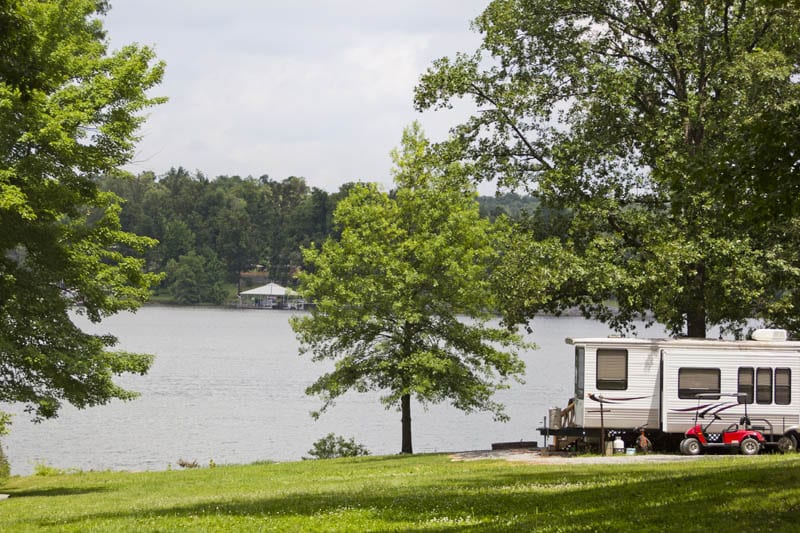 Camper and golf cart next to the lake.